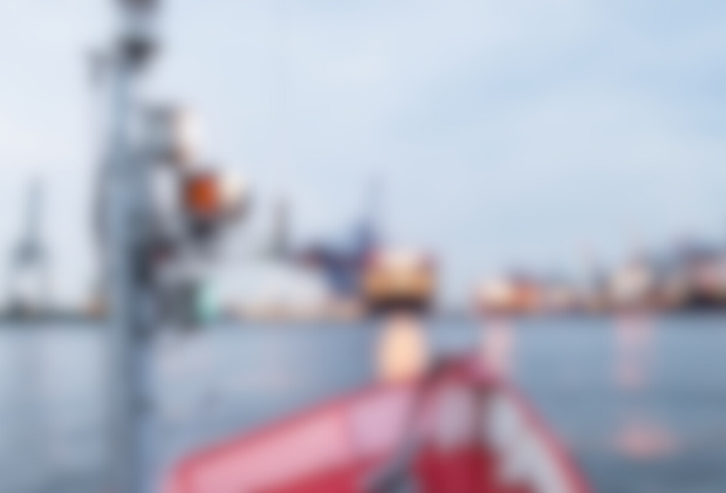 Unscharfe Aufnahme eines Hafens mit Wasser, Schiffen und Hafenkränen