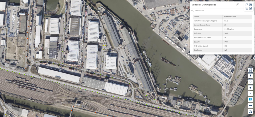 Luftaufnahme eines Industriegebiets mit Hafenbecken, Lagerhallen und Bahngleisen